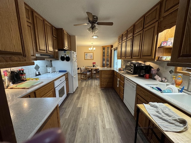 kitchen with tasteful backsplash, a textured ceiling, white appliances, decorative light fixtures, and dark hardwood / wood-style floors