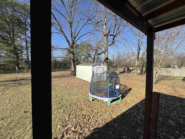 view of yard featuring a storage unit, an outdoor structure, and fence