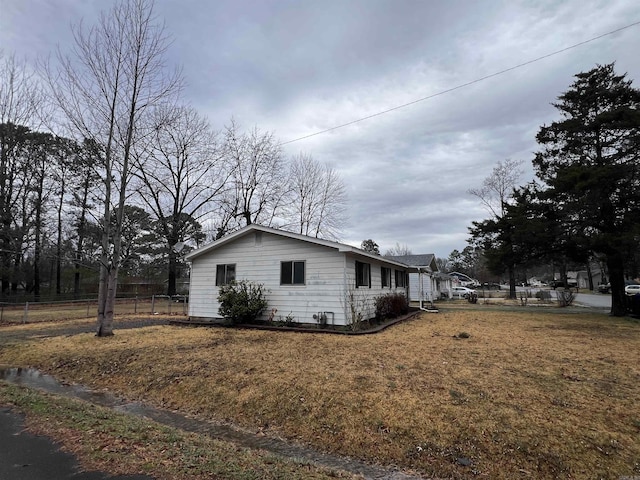 view of home's exterior featuring a yard and fence