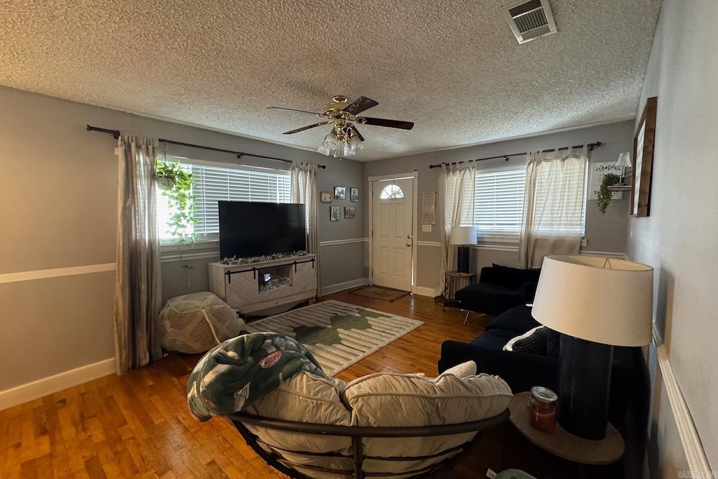 living room featuring a wealth of natural light, hardwood / wood-style flooring, and ceiling fan