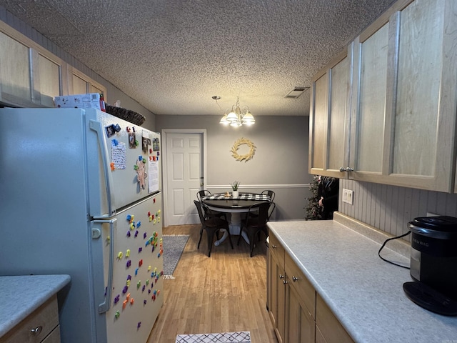 kitchen featuring a chandelier, visible vents, light countertops, light wood-type flooring, and freestanding refrigerator