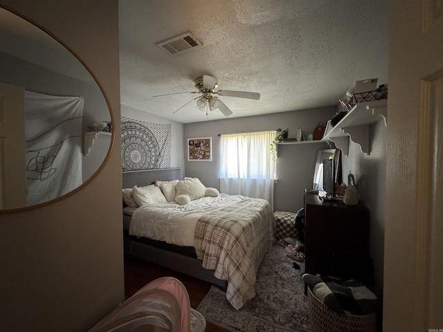 bedroom featuring a textured ceiling, ceiling fan, and visible vents