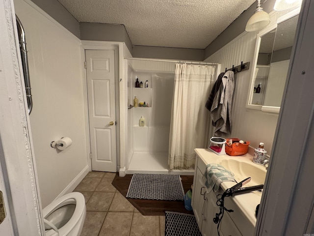 full bathroom featuring a textured ceiling, curtained shower, tile patterned flooring, and vanity