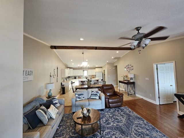 living room with hardwood / wood-style flooring, ceiling fan with notable chandelier, lofted ceiling with beams, and ornamental molding