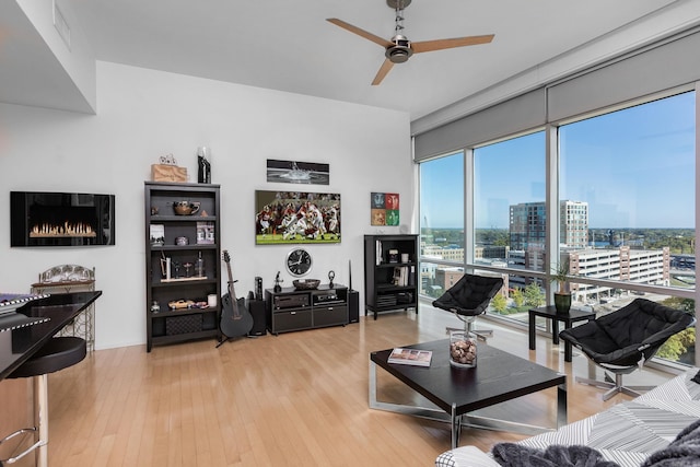 living room featuring ceiling fan and light hardwood / wood-style flooring