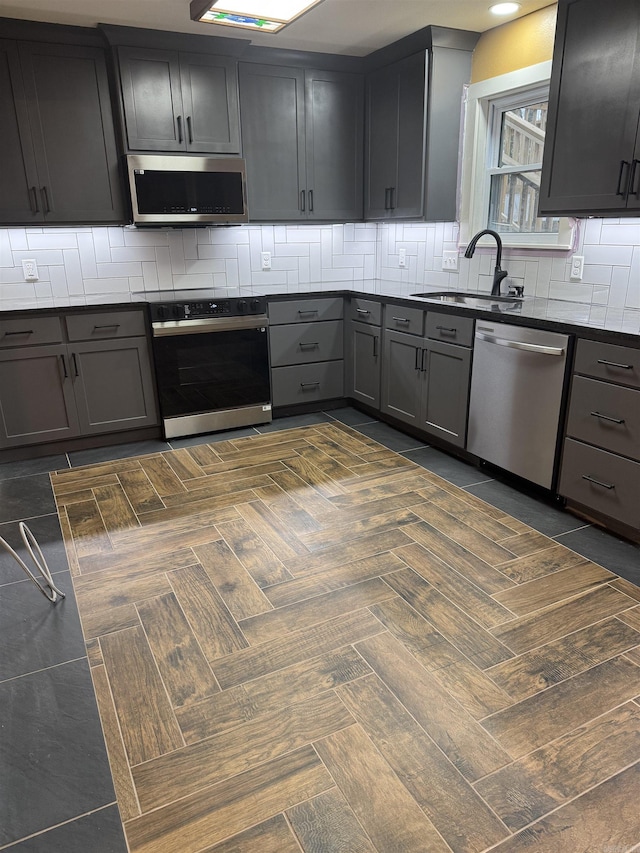 kitchen featuring gray cabinets, sink, and stainless steel appliances