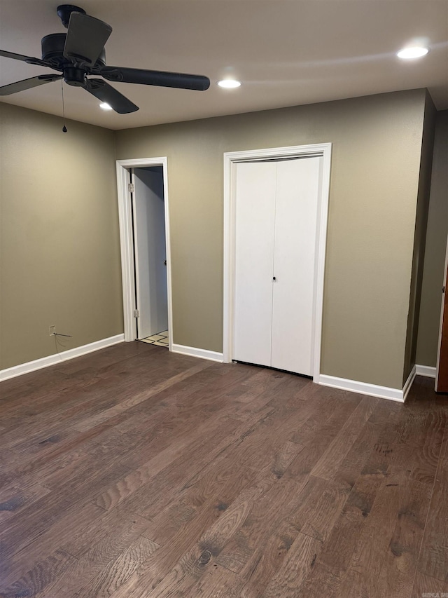 unfurnished bedroom with ceiling fan, a closet, and dark hardwood / wood-style floors