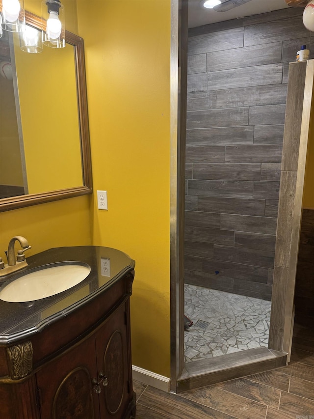 bathroom featuring a tile shower and vanity