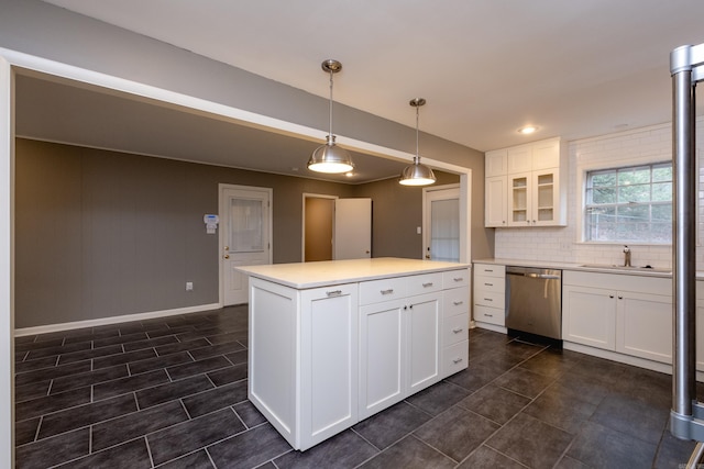 kitchen with dishwasher, sink, decorative light fixtures, a kitchen island, and white cabinetry