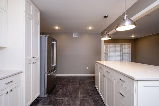 kitchen with high quality fridge, white cabinetry, a center island, and hanging light fixtures