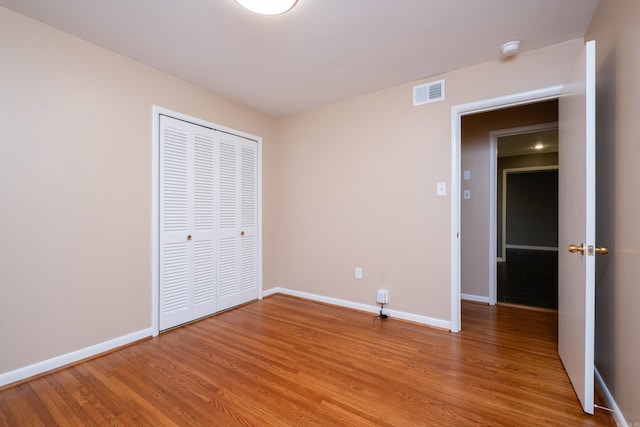 unfurnished bedroom featuring wood-type flooring and a closet