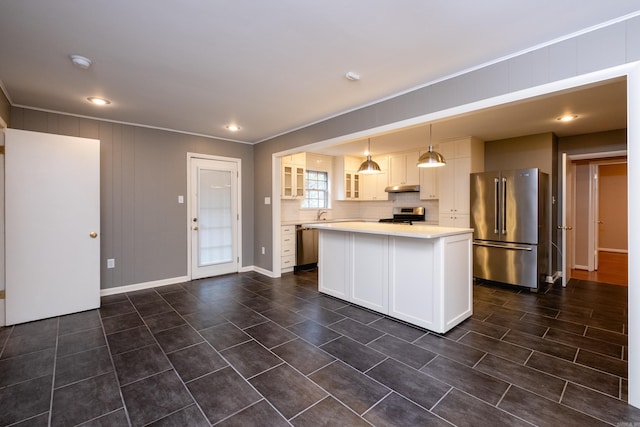 kitchen with appliances with stainless steel finishes, decorative light fixtures, a kitchen island, and white cabinetry