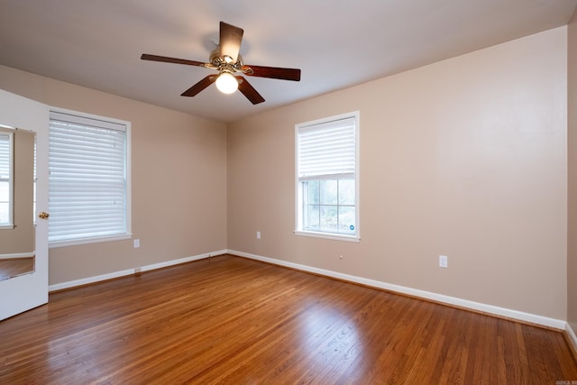 spare room featuring a wealth of natural light, hardwood / wood-style floors, and ceiling fan