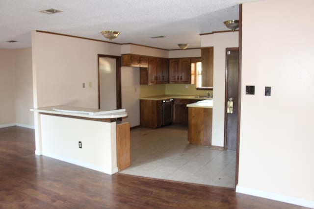 kitchen featuring sink, dishwasher, light hardwood / wood-style flooring, white fridge, and a textured ceiling