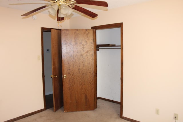 unfurnished bedroom featuring ceiling fan, a closet, and light colored carpet