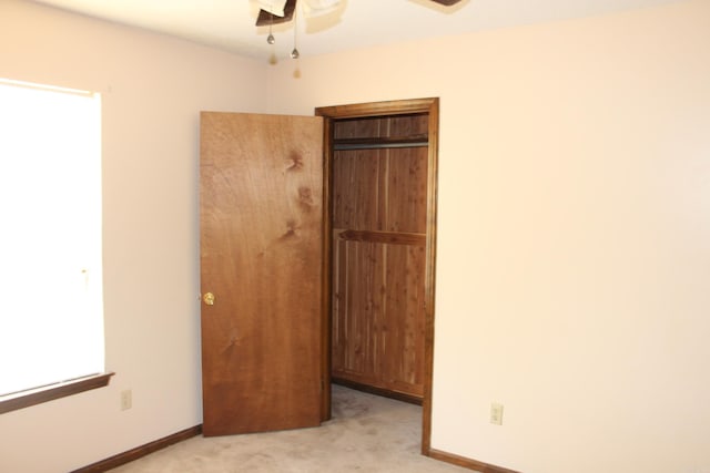 unfurnished bedroom featuring light carpet and ceiling fan