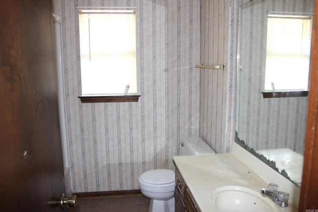 bathroom with toilet, vanity, and tile patterned floors