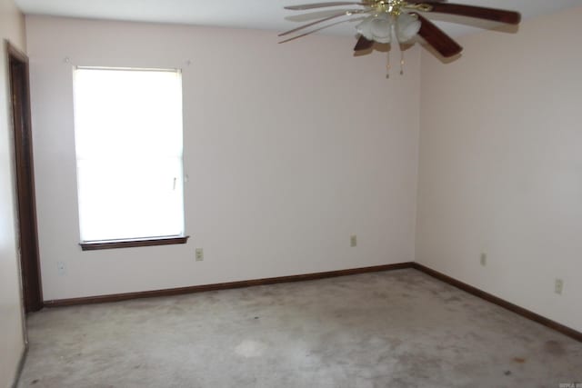 carpeted spare room featuring ceiling fan and a healthy amount of sunlight