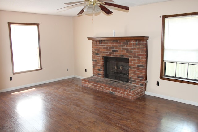 unfurnished living room with a fireplace, dark hardwood / wood-style floors, and ceiling fan