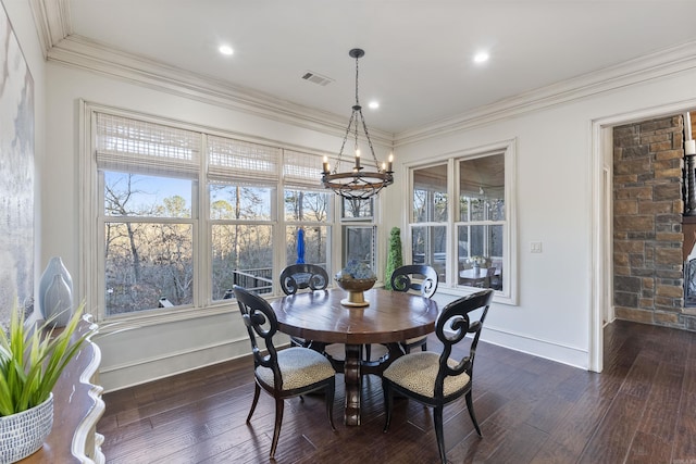 dining area featuring ornamental molding, dark wood-type flooring, and a notable chandelier