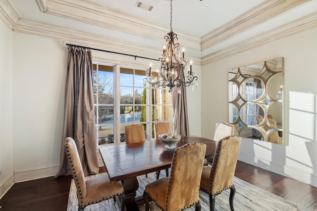 dining area featuring ornamental molding, dark wood-type flooring, and a chandelier