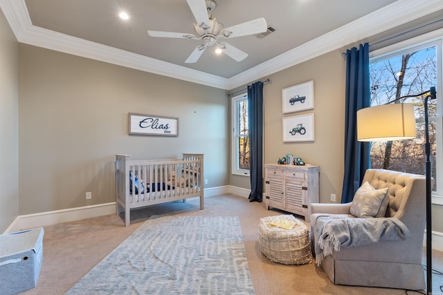 carpeted bedroom featuring ceiling fan, a nursery area, and ornamental molding