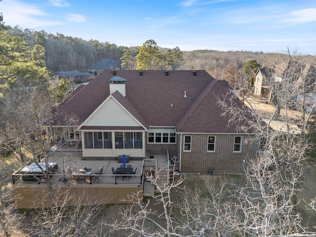 rear view of property with a wooden deck and a sunroom