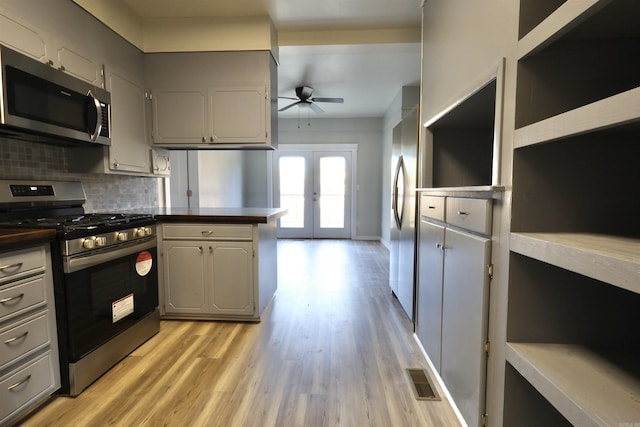 kitchen with gray cabinetry, ceiling fan, french doors, stainless steel appliances, and decorative backsplash