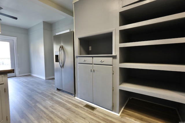 kitchen featuring white cabinets, ceiling fan, stainless steel fridge, and light hardwood / wood-style floors