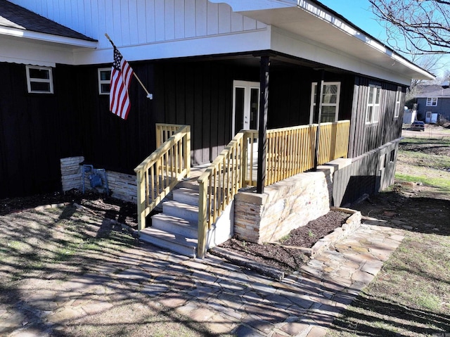 view of side of home with french doors and covered porch