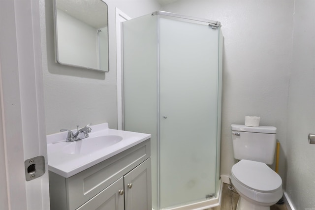 bathroom featuring walk in shower, vanity, and toilet