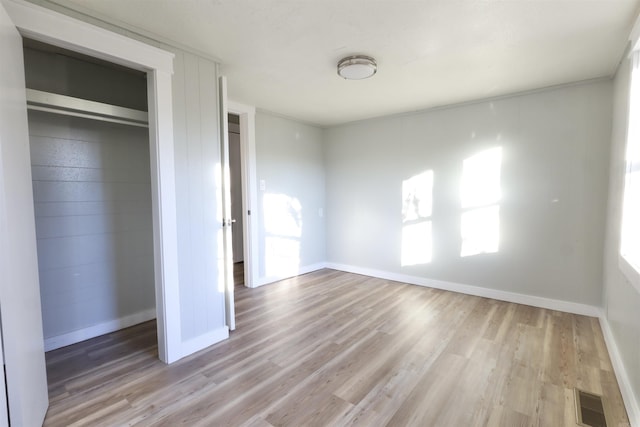 unfurnished bedroom featuring a closet and light hardwood / wood-style floors