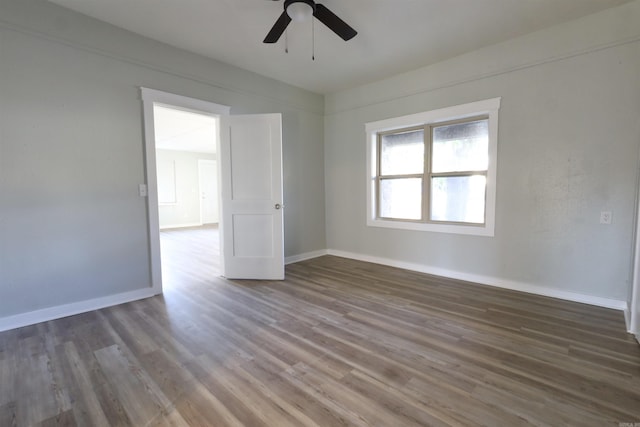 spare room with ceiling fan and dark wood-type flooring