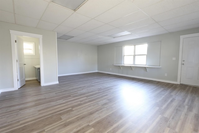 unfurnished room featuring a paneled ceiling and light hardwood / wood-style floors