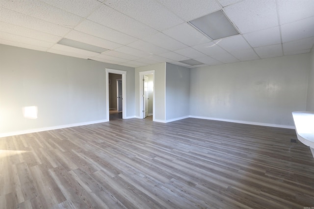 empty room featuring hardwood / wood-style floors and a drop ceiling