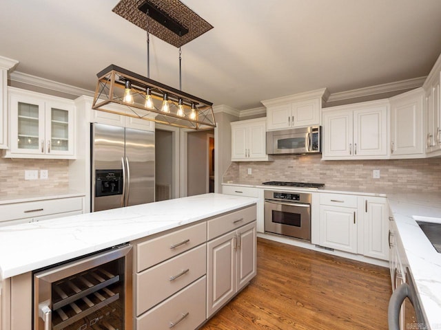 kitchen featuring wine cooler, white cabinets, stainless steel appliances, and decorative light fixtures