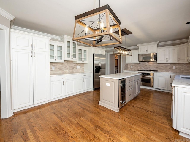 kitchen featuring stainless steel appliances, a kitchen island, pendant lighting, white cabinetry, and wine cooler