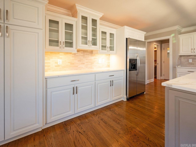 kitchen with tasteful backsplash, stainless steel fridge with ice dispenser, dark hardwood / wood-style flooring, crown molding, and white cabinets