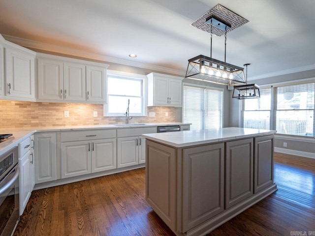 kitchen with white cabinets, stainless steel appliances, a kitchen island, and sink