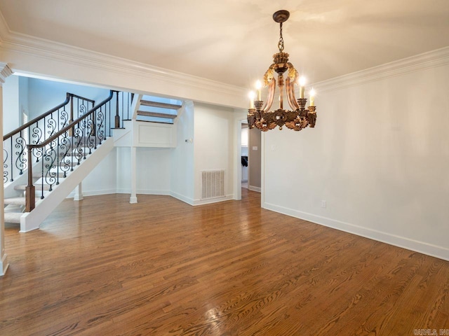 unfurnished living room with hardwood / wood-style flooring, crown molding, and a notable chandelier