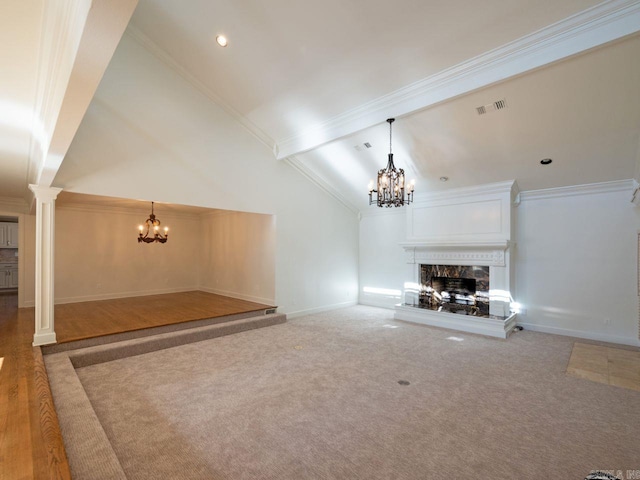 unfurnished living room featuring carpet, ornamental molding, high vaulted ceiling, and decorative columns