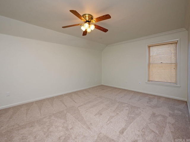 spare room featuring light carpet, crown molding, ceiling fan, and lofted ceiling