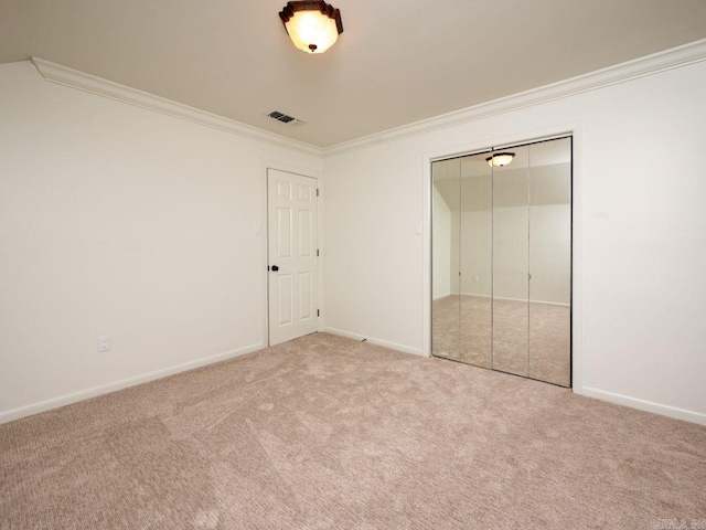 unfurnished bedroom with carpet flooring, crown molding, and a closet