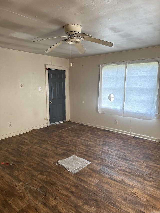 empty room with a textured ceiling, ceiling fan, and dark wood-type flooring