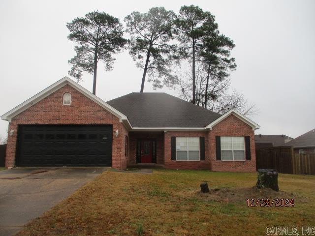 ranch-style home with a garage and a front lawn