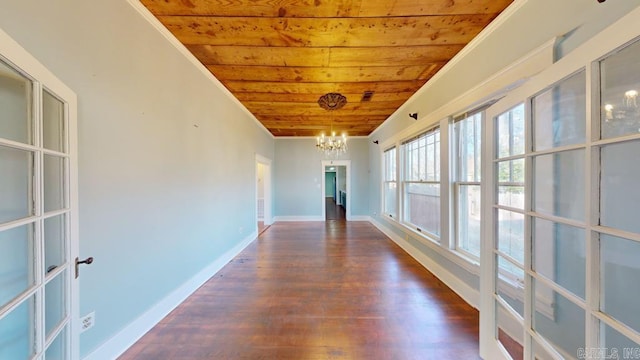 hall featuring dark hardwood / wood-style floors, wood ceiling, crown molding, and an inviting chandelier