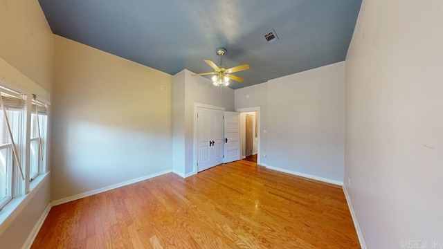 empty room featuring light hardwood / wood-style flooring, a wealth of natural light, and ceiling fan