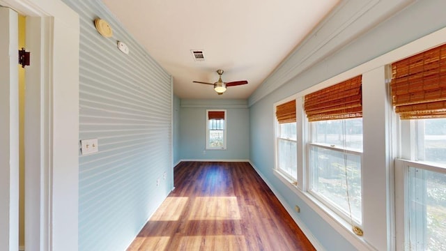 hall with dark wood-type flooring and a healthy amount of sunlight