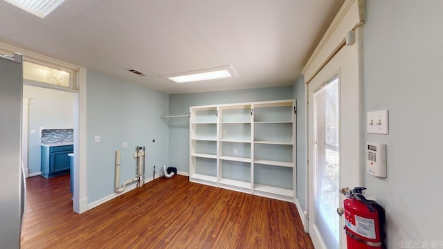 clothes washing area with dark hardwood / wood-style floors and a wealth of natural light