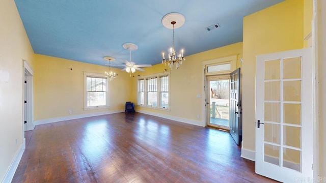 empty room with dark hardwood / wood-style floors and ceiling fan with notable chandelier